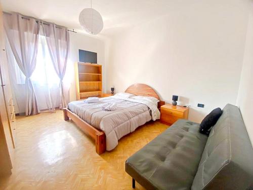 een slaapkamer met een bed en een bank erin bij Giulia home in Monfalcone