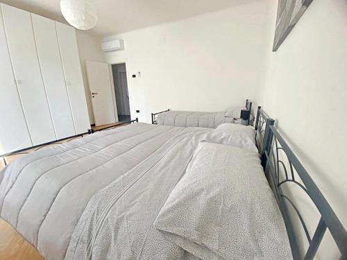 a white bedroom with two beds in it at Giulia home in Monfalcone