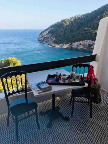 een tafel en stoelen op een balkon met uitzicht op de oceaan bij De Balearibus in Cala Llonga