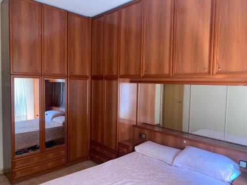 1 dormitorio con armarios de madera y 1 cama en Apartamento Bàsico, en Cala Llonga