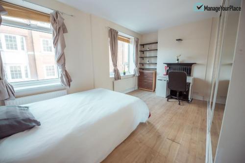 sypialnia z białym łóżkiem i biurkiem w obiekcie Great Central London Flat w Londynie