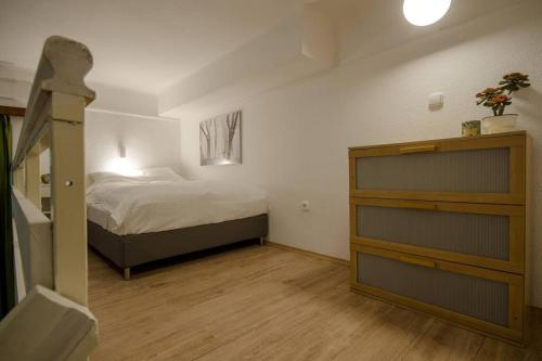 a small bedroom with a bed and a dresser at DE LUX Studio Apartment In Historical Quarters in Budapest