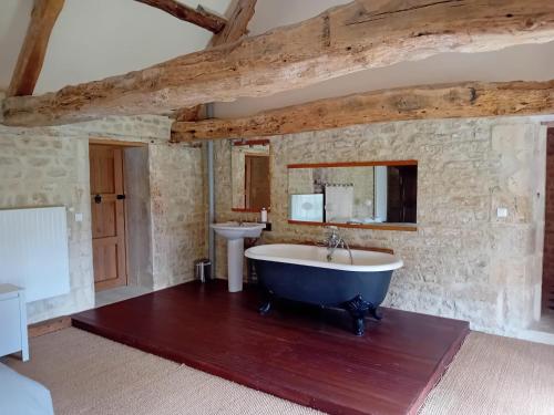 ein großes Bad mit einer Badewanne und einem Waschbecken in der Unterkunft Magnifique château rénové proche bourg grand parc belle terrasse billard, ping pong, proche Bayeux et plages du débarquement in Tilly-sur-Seulles