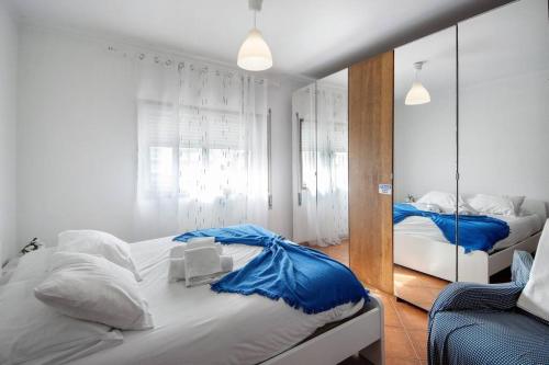 a bedroom with two beds and a mirror at Manny's place - by the sea in Gafanha da Nazaré