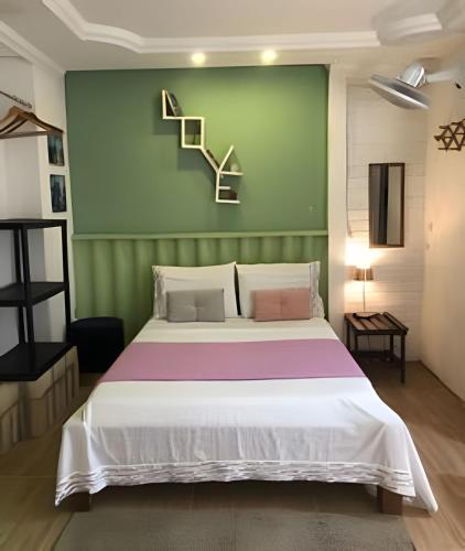 a bedroom with a bed and a green wall at A Joia de Olinda in Olinda