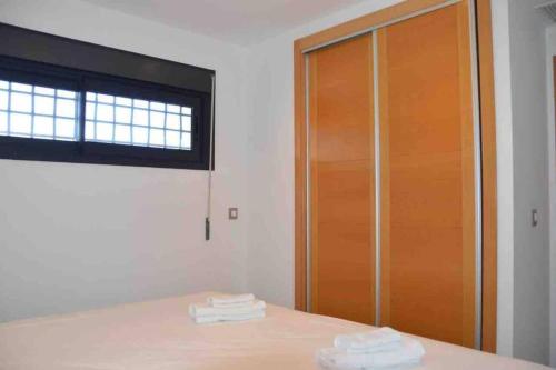 a room with a wooden door and towels on a table at Ibo beach apartment Albir in Albir