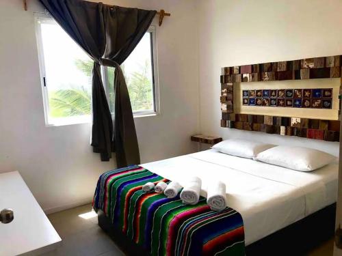 1 dormitorio con 1 cama grande y ventana en Tuna Fish, Ocean Front Apartment en Mahahual