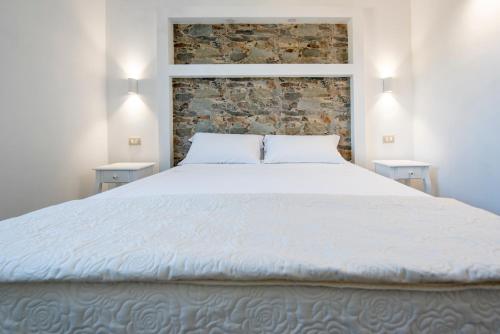 a bedroom with a large white bed with two tables at Villa del Papiro Charme Apartments in Avola