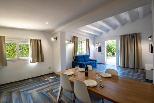 a dining room and living room with a table and chairs at Villa del Papiro Charme Apartments in Avola