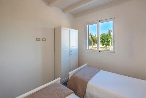 a bedroom with two beds and a window at Villa del Papiro Charme Apartments in Avola