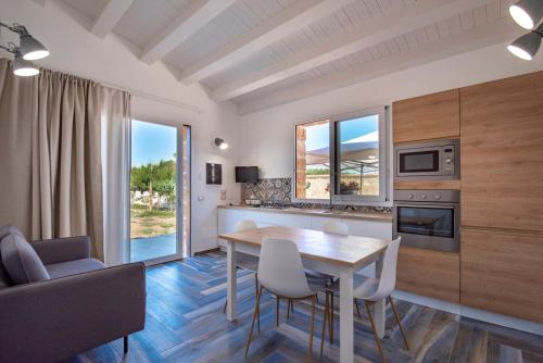 uma cozinha e sala de jantar com mesa e cadeiras em Villa del Papiro Charme Apartments em Avola