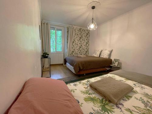 een slaapkamer met 2 bedden en een raam bij Gîte du RELAI du Château - Parc Oriental - Puy du Fou in La Tourlandry