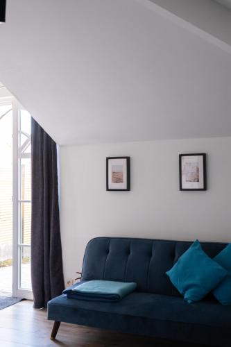 a blue couch in a living room with white walls at B&B De Joker in Turnhout