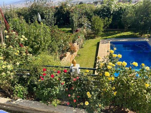 un jardín con piscina y flores en La Perla Montaña Tanger en Tánger