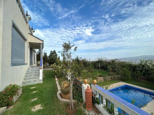 un patio trasero con piscina y una casa en La Perla Montaña Tanger en Tánger