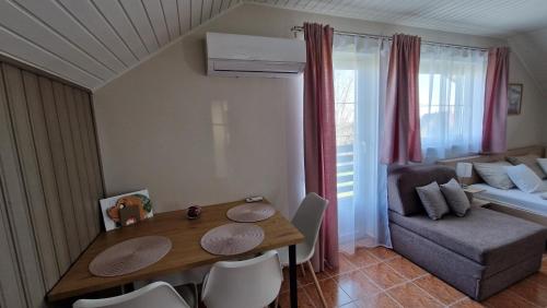 a small living room with a table and a couch at Silence Apartmanház Zalakaros in Zalakaros