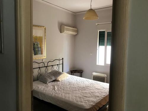 Schlafzimmer mit einem Bett und einem Fenster in der Unterkunft Palaio Faliro Plaza με Jacuzzi και Τζάκι in Athen
