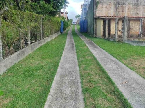 an empty street with a fence and grass at Igaratá Beach Casa em Igaratá Pé na água in Igaratá