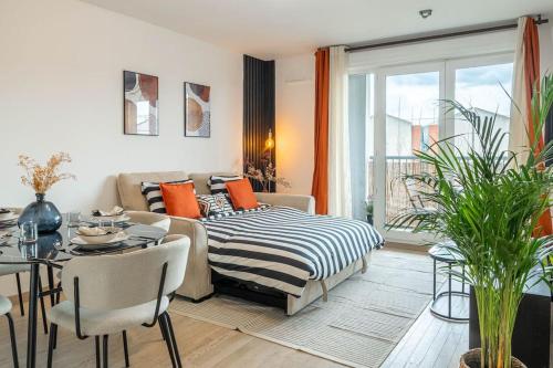 een woonkamer met een bank, een bed en een tafel bij HarmonyHome_À 10 min de Paris/ Free Parking in Montreuil