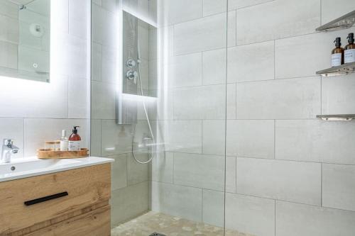 een witte badkamer met een douche en een wastafel bij HarmonyHome_À 10 min de Paris/ Free Parking in Montreuil