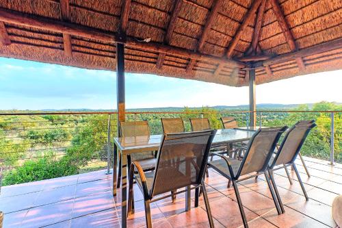 a table and chairs on a balcony with a view at Shasha Lodge, Mabalingwe Game Reserve in Mabula