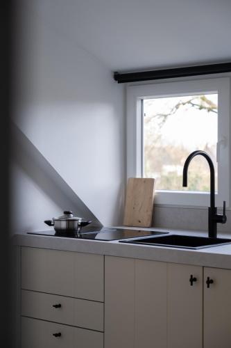 a kitchen counter with a sink and a window at B&B De Joker in Turnhout