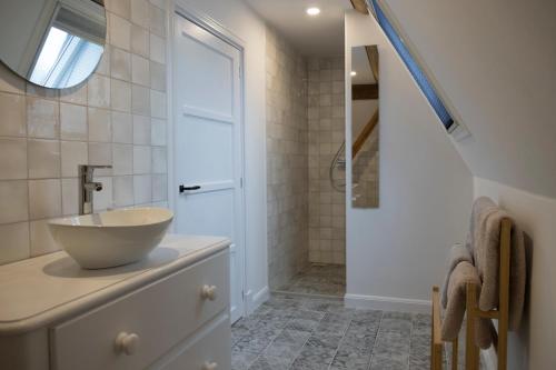 ein Bad mit einem Waschbecken und einer Dusche in der Unterkunft B&B Buurvrouw Buurman in Blankenham
