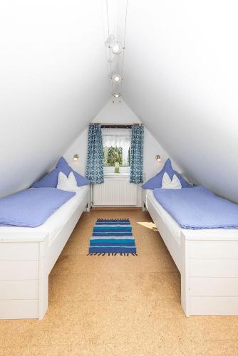 a attic bedroom with two beds and a window at Haus Delphin in Juist