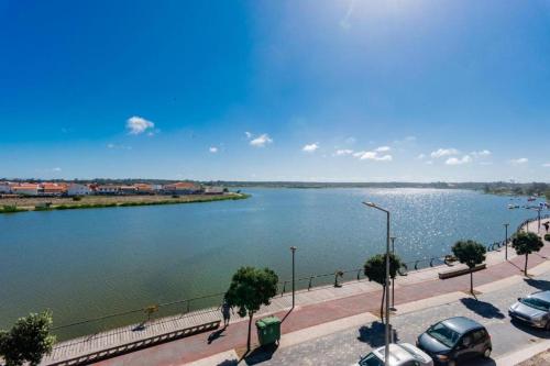 a large body of water with cars parked next to it at Bela Vista Barrinha in Praia de Mira