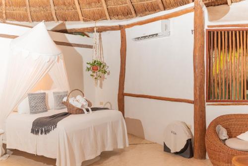 a bedroom with a bed and a table and a lamp at Casa Takywara in Holbox Island