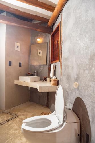 a bathroom with a toilet and a sink at Casa Takywara in Holbox Island