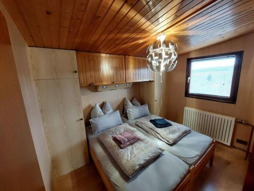 1 dormitorio con 1 cama grande y lámpara de araña en Ferienhaus Eifel Nature Dream II, en Dockweiler