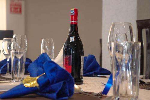 uma garrafa de vinho sentada numa mesa com copos em BUNGOMA ROYAL SUITES em Bungoma