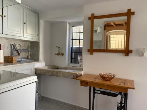 a kitchen with a sink and a mirror on the wall at Lemon House in Hydra