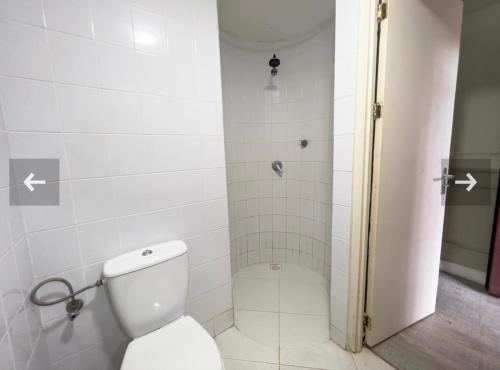 een badkamer met een toilet en een douche bij Ark of Reset in Paramaribo