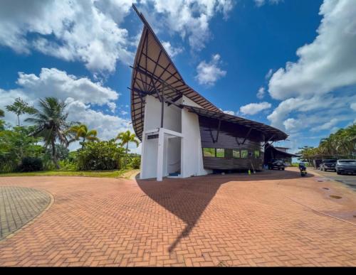 un bâtiment avec un toit escarpé sur une route en briques dans l'établissement Ark of Reset, à Paramaribo
