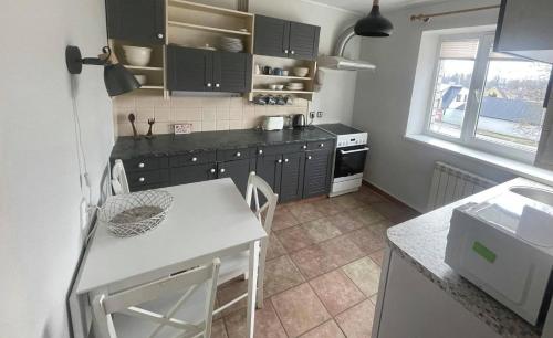 eine Küche mit schwarzen Schränken sowie einem weißen Tisch und Stühlen in der Unterkunft Vabaduse Apartment in Kärdla