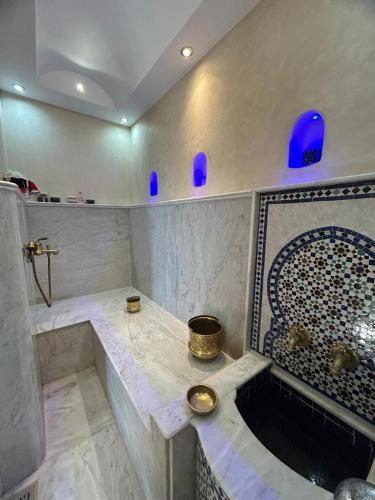 a bathroom with a tub and a sink with blue vases at La Perla Montaña Tanger in Tangier