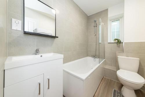 a white bathroom with a sink and a toilet at 2 Bedroom Flat Free Parking in Reading