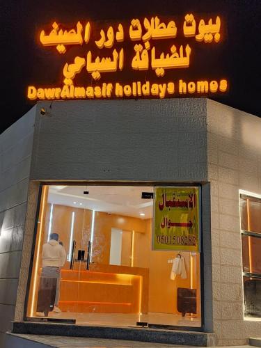 a sign above a window of a hotel at بيوت عطلات دور المصيف للضيافة السياحي in Qarār