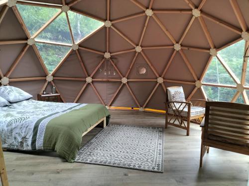 a bedroom in a yurt with a bed and a chair at Petite Fugue in Cransac