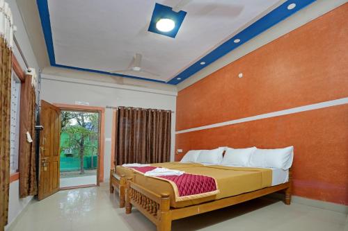 Hillside Spring Valley Resort Masinagudi في ماسيناجودي: غرفة نوم بسرير ونافذة كبيرة