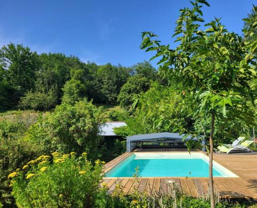une piscine au milieu d'un jardin dans l'établissement Petite Fugue, à Cransac