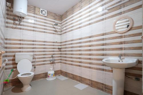 a bathroom with a toilet and a sink at Hillside Spring Valley Resort Masinagudi in Masinagudi