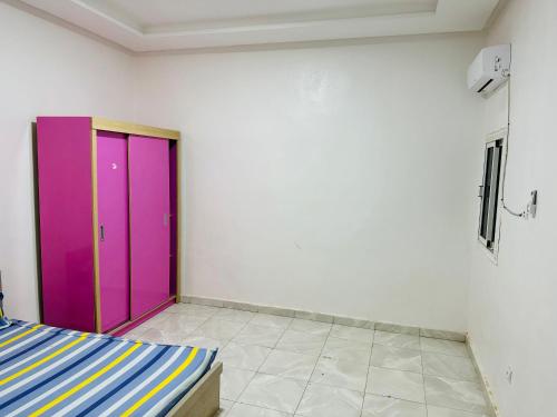 una camera con una porta viola e una parete bianca di Duplex neuf meublé a Nouakchott