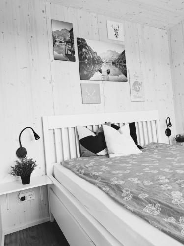 1 dormitorio con 1 cama y cuadros en la pared en Nature Living Koralm - Neue Chalets auf der Koralpe im Schi- und Wanderparadies en Sankt Stefan im Lavanttal