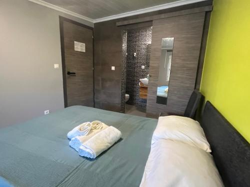 a bedroom with a bed with a towel and a bathroom at Sun house - Near Sintra - Kitchen - Pool in Sintra