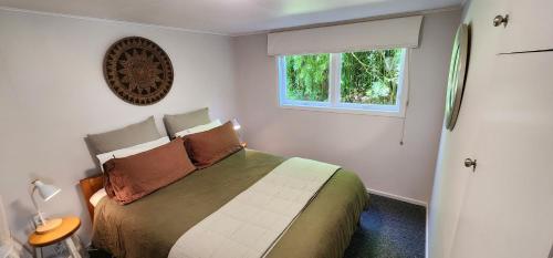 a bedroom with a bed and a window at Perfect Lakeside Summer House in Rotorua