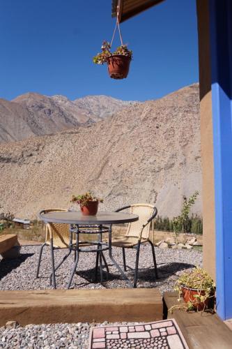 a patio with a table and chairs and a mountain at Cumbres de Alcohuaz in Alcoguaz