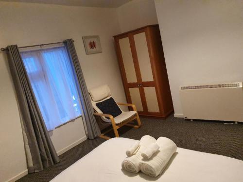 a room with a bed and a chair and a window at Cosy stay in private double bedroom - RM 5 in Nottingham